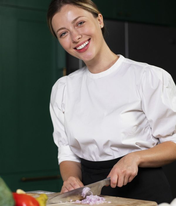 medium-shot-smiley-woman-cutting-onion-min